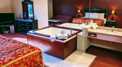 Executive Whirlpool Suite at Grand Marquis Hotel in Wisconsin Dells - main view with full view of whirlpool and partial view of tv, bed, and vanity