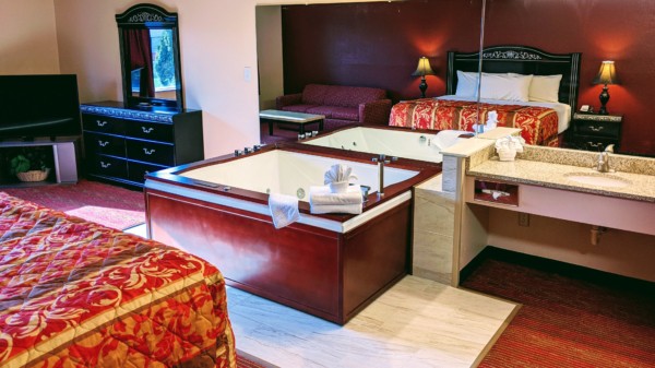 Executive Whirlpool Suite at Grand Marquis Hotel in Wisconsin Dells - main view with full view of whirlpool and partial view of tv, bed, and vanity