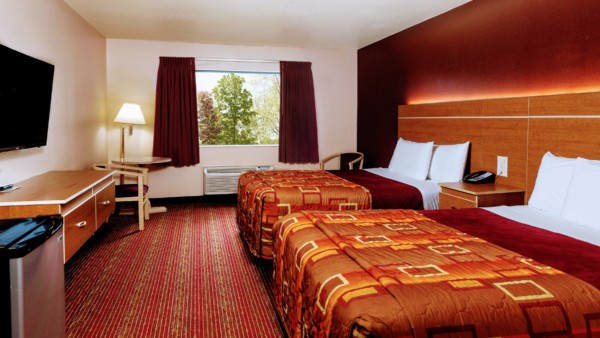 Guest room at Grand Marquis Hotel with 2 queen beds, mini fridge, and HD TV - view into the room from entrance