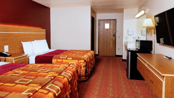 Guest room at Grand Marquis Hotel with 2 queen beds, mini fridge, and HD TV - view when inside the room by the window, towards the entrance