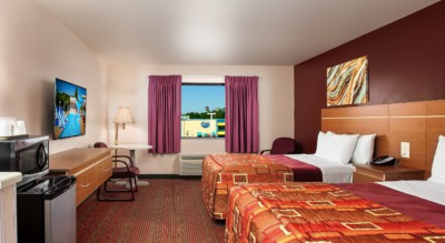 Guest room at Grand Marquis Hotel with 2 queen beds, mini fridge, and HD TV - view into the room from the entrance