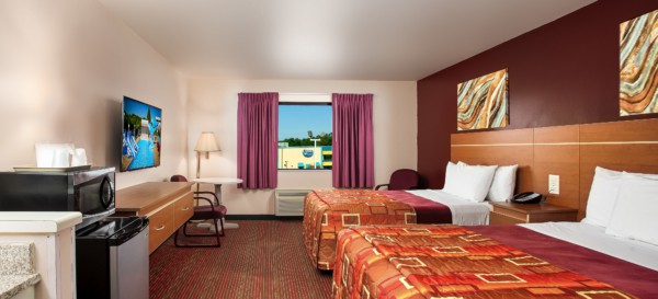 Guest room at Grand Marquis Hotel with 2 queen beds, mini fridge, and HD TV - view into the room from the entrance