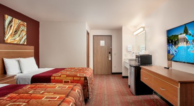 Guest room at Grand Marquis Hotel with 2 queen beds, mini fridge, and HD TV - view when inside the room by the window, towards the entrance