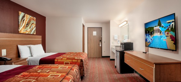 Guest room at Grand Marquis Hotel with 2 queen beds, mini fridge, and HD TV - view when inside the room by the window, towards the entrance