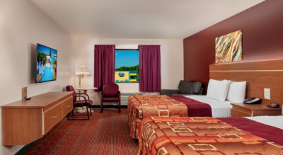 Junior Studio Suite at Grand Marquis Hotel - front view of beds, couch, table and chairs, tv, and floating dresser