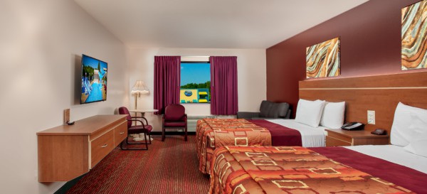 Junior Studio Suite at Grand Marquis Hotel - front view of beds, couch, table and chairs, tv, and floating dresser